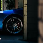 A blue sports car pulls out of a garage