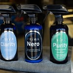 Three bottles of Prima car care products sit in a row Prima Clarity Nero and Purity