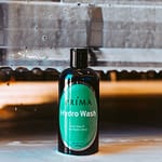 A bottle of Prima Hydro Wash sits in front of a soapy car